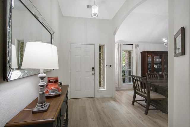 entryway with vaulted ceiling and light wood-type flooring