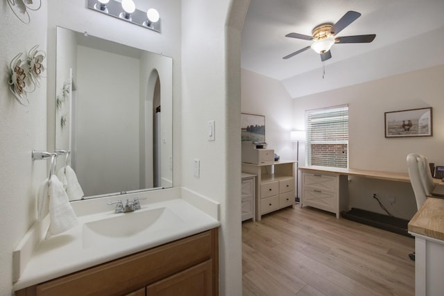 bathroom with ceiling fan, hardwood / wood-style floors, vanity, and vaulted ceiling