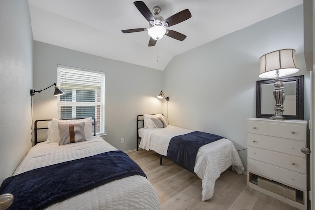 bedroom with ceiling fan, lofted ceiling, and light hardwood / wood-style flooring