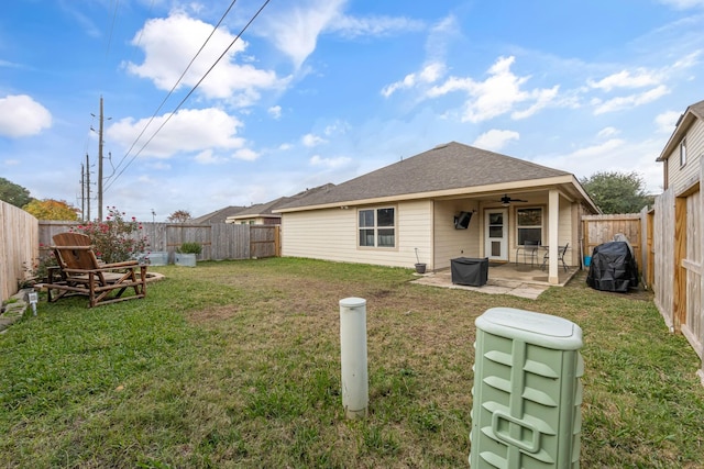 back of house featuring a lawn, ceiling fan, and a patio