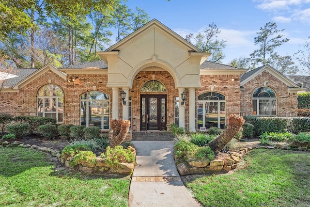 doorway to property featuring a yard and french doors