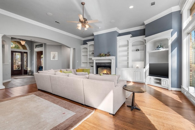 living room with plenty of natural light, ceiling fan, ornamental molding, and french doors