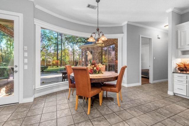 dining area with light tile patterned flooring, ornamental molding, and a notable chandelier