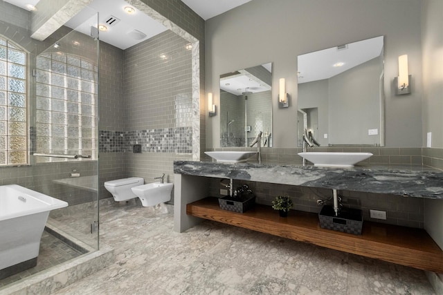 full bathroom featuring shower with separate bathtub, a bidet, toilet, vanity, and tile walls