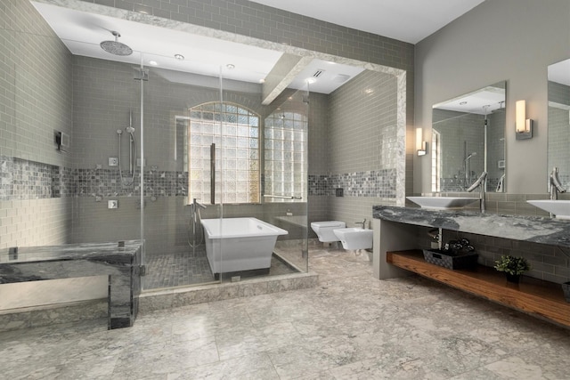 bathroom with vanity, separate shower and tub, tile walls, and a bidet