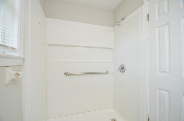 bathroom featuring a tile shower and a textured ceiling