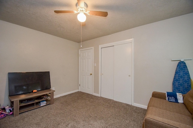 carpeted living room with a textured ceiling and ceiling fan