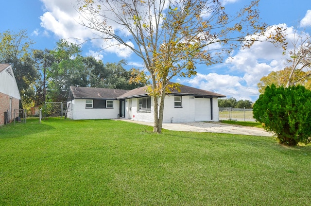 rear view of house with a garage and a yard