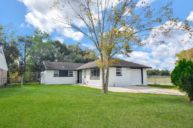 rear view of property featuring a garage and a lawn