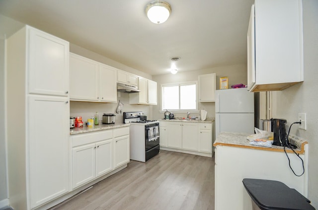 kitchen with light wood-type flooring, white appliances, white cabinetry, and sink