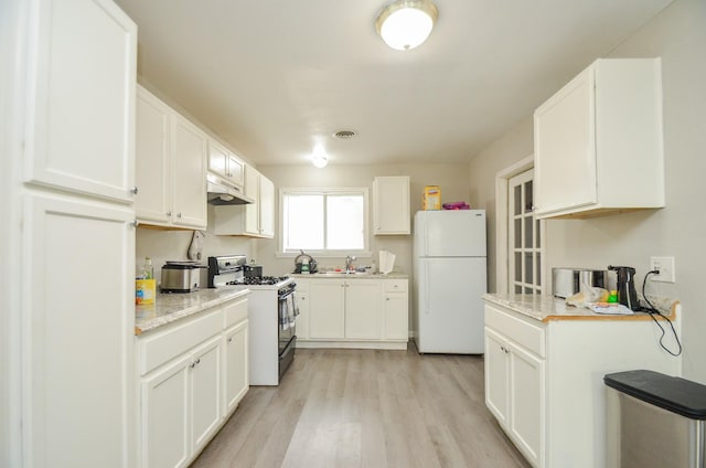 kitchen with sink, light stone counters, light hardwood / wood-style flooring, white appliances, and white cabinets