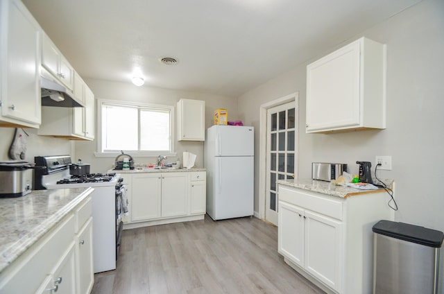 kitchen featuring light stone countertops, white appliances, light hardwood / wood-style floors, and white cabinetry