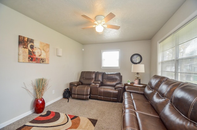 carpeted living room featuring ceiling fan and a textured ceiling