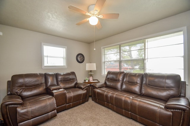 living room with ceiling fan, light colored carpet, and a textured ceiling