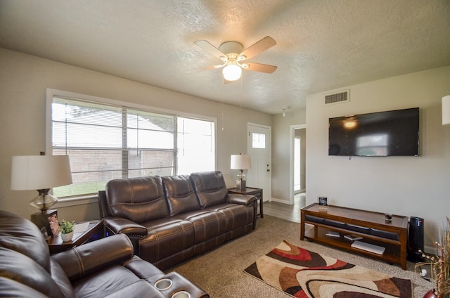 carpeted living room featuring a textured ceiling and ceiling fan