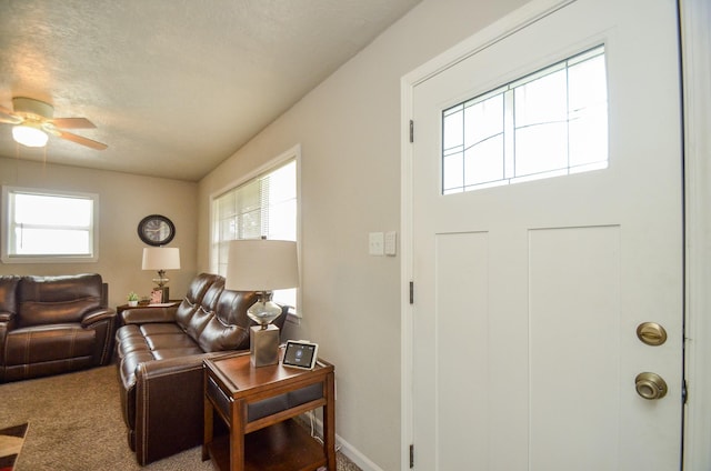 living room featuring ceiling fan, carpet, and a textured ceiling