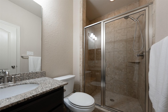 bathroom featuring vanity, toilet, and a shower with shower door