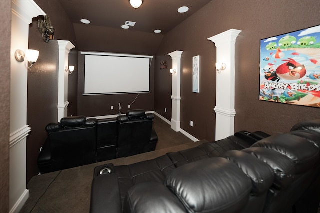 home theater featuring dark colored carpet, lofted ceiling, and decorative columns