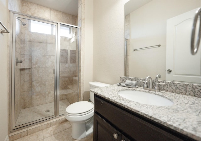 bathroom featuring tile patterned floors, vanity, toilet, and walk in shower