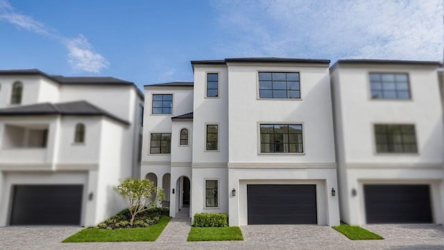 view of front of home with driveway, a garage, and stucco siding