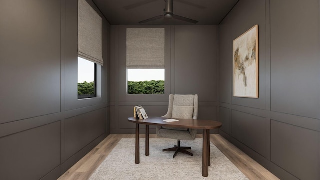 home office with ceiling fan, light wood-type flooring, and a decorative wall