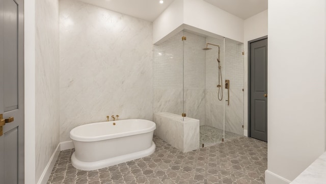 full bath featuring a freestanding tub, baseboards, and a walk in shower