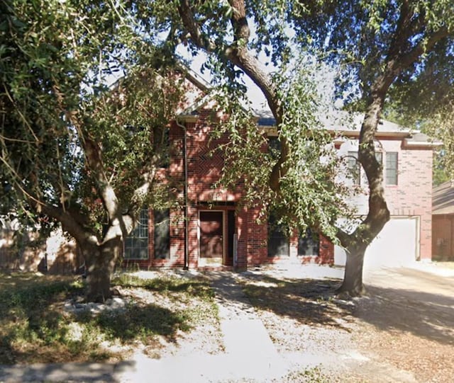 view of property hidden behind natural elements with a garage