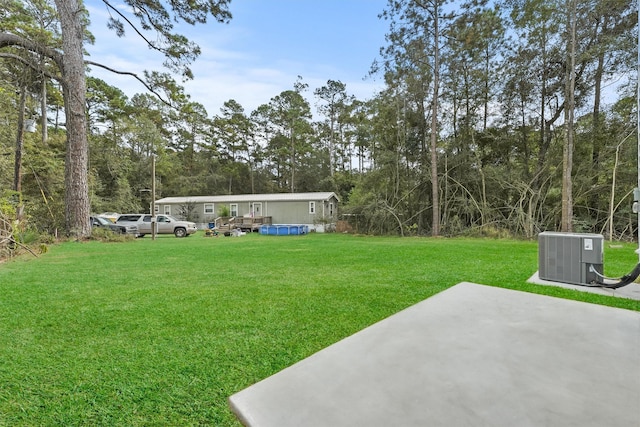 view of yard with central AC, a patio area, and a swimming pool