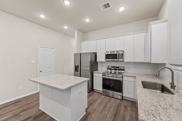 kitchen featuring a center island, sink, dark hardwood / wood-style flooring, white cabinetry, and stainless steel appliances