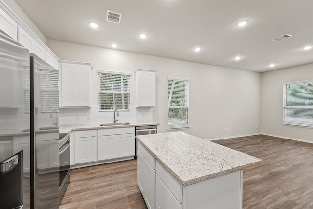 kitchen featuring white cabinetry, a wealth of natural light, tasteful backsplash, and a kitchen island