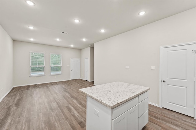 kitchen featuring white cabinetry, light hardwood / wood-style flooring, and a center island