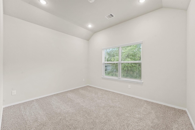 unfurnished room featuring carpet and lofted ceiling