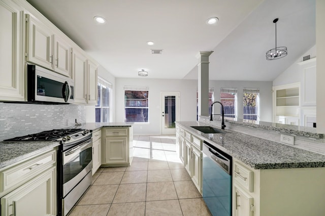 kitchen featuring light stone countertops, sink, hanging light fixtures, stainless steel appliances, and lofted ceiling