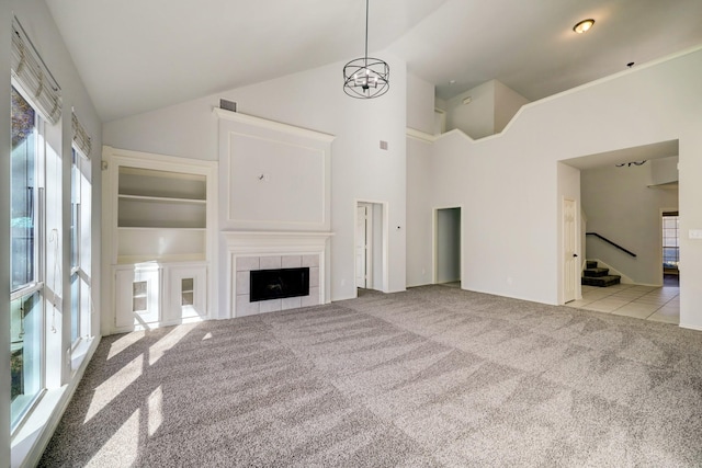 unfurnished living room featuring light carpet, high vaulted ceiling, and a fireplace