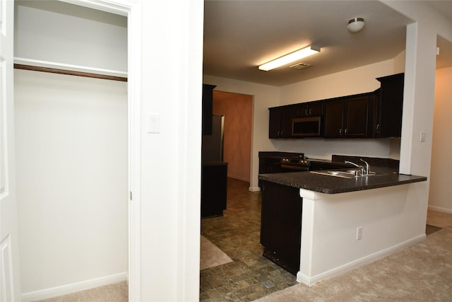 kitchen with carpet floors, sink, electric range, dark brown cabinets, and kitchen peninsula