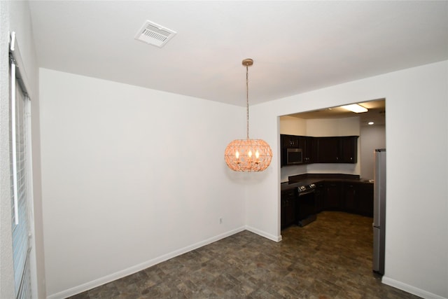 kitchen with appliances with stainless steel finishes, hanging light fixtures, and a notable chandelier