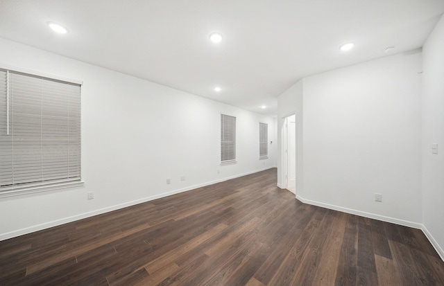 unfurnished room with recessed lighting, visible vents, baseboards, and dark wood finished floors