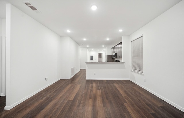 unfurnished living room featuring dark wood finished floors, recessed lighting, visible vents, and baseboards