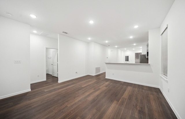 unfurnished living room featuring recessed lighting, dark wood-style floors, and visible vents