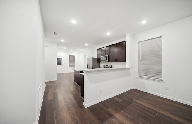 kitchen with recessed lighting, dark brown cabinets, appliances with stainless steel finishes, and dark wood-style flooring