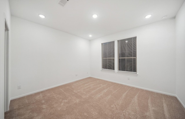 unfurnished room featuring recessed lighting, baseboards, visible vents, and light carpet