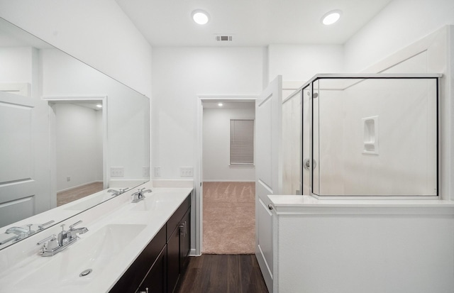 bathroom with a sink, visible vents, a stall shower, and double vanity