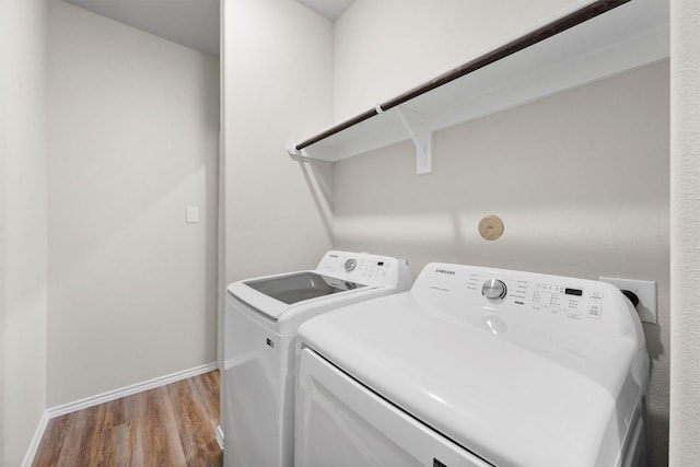 laundry room featuring independent washer and dryer and light hardwood / wood-style flooring