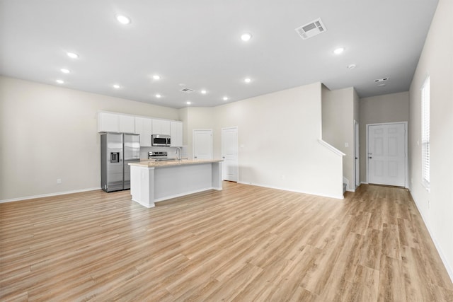 unfurnished living room featuring light hardwood / wood-style floors and sink