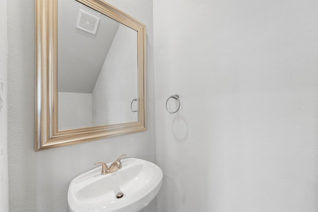 bathroom with lofted ceiling and sink