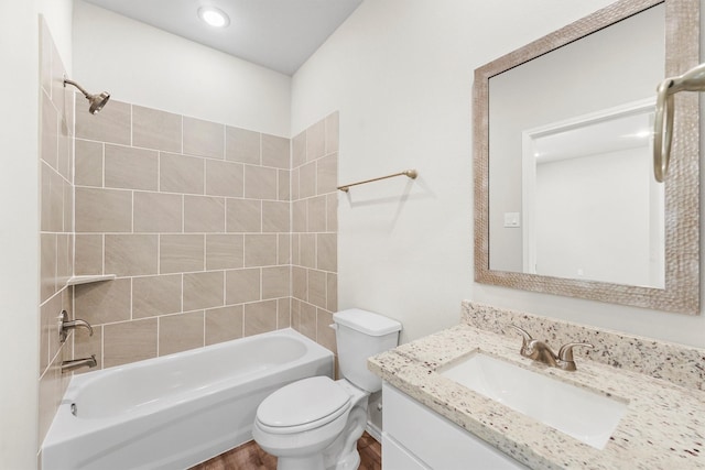 full bathroom with vanity, hardwood / wood-style floors, tiled shower / bath combo, and toilet