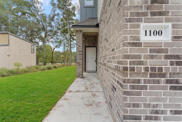 view of exterior entry with a yard