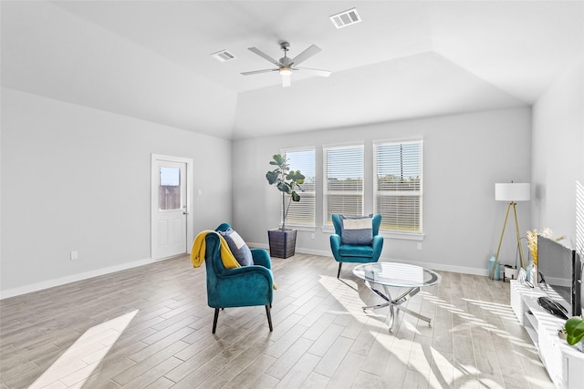 living area with ceiling fan, light hardwood / wood-style flooring, and vaulted ceiling