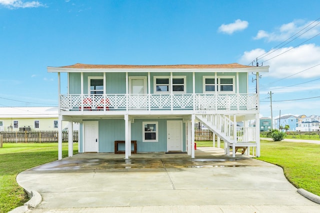 view of front of home with a front yard, a carport, and covered porch