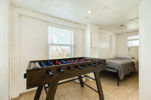 recreation room featuring light tile patterned floors and a paneled ceiling